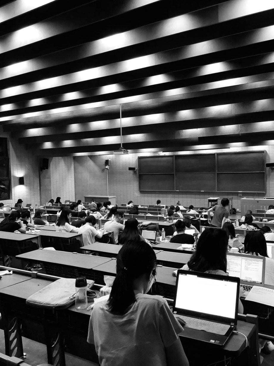 a black and white photo of students in the lecture hall.