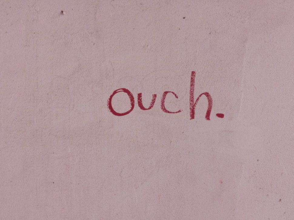 ouch sign written in red on a light background