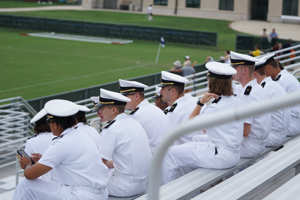 A group of members of the naval force are sitting together.