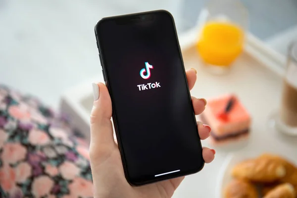 handle holding black phone and opening the TikTok application 