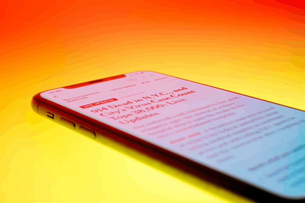 black android smartphone on orange surface showing a long text of headline