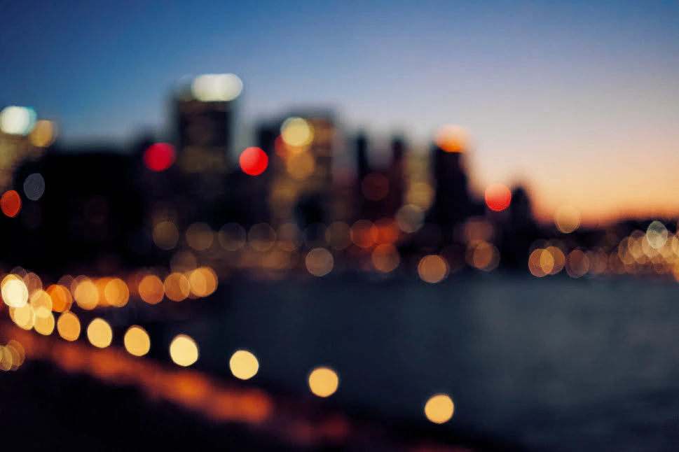 A blurry image of a city landscape with lights. 