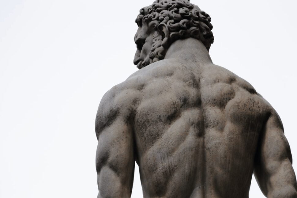 A statute of a muscular man with his back turned.