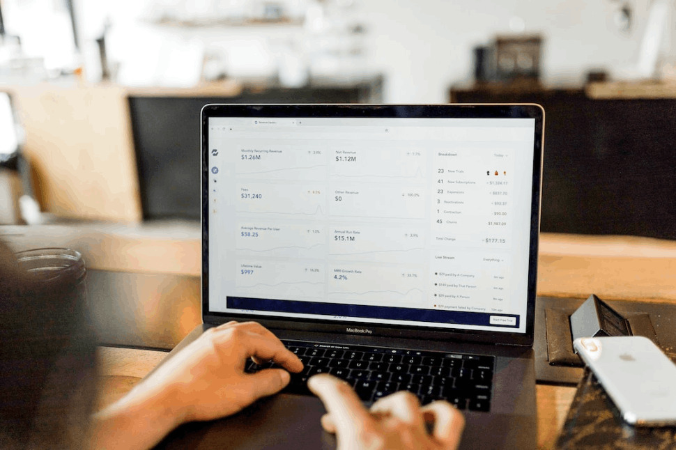 person using black MacBook pro laptop on brown table