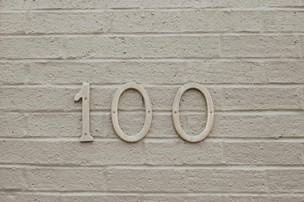 Inscription of 100 on milky wall with parallel lines