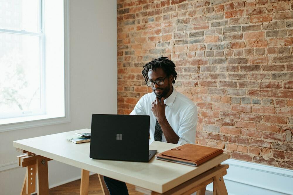 Photo of a sharp-dressed man in front of a Windows Laptop.
