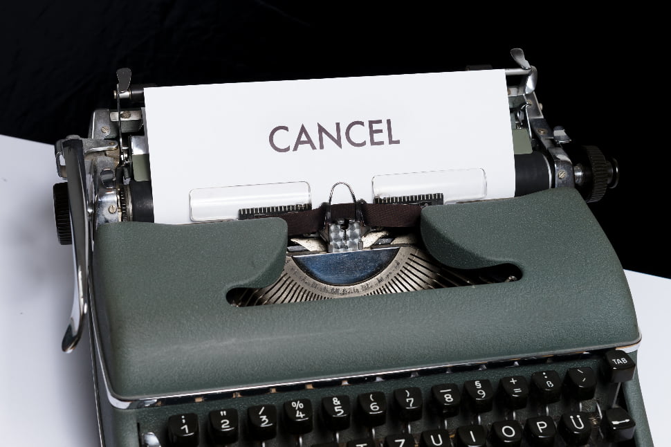 A typewriter that has printed the word Cancel on a piece of paper.