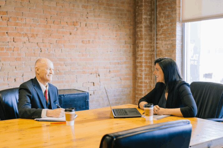 a man and woman talking inside an office conference room