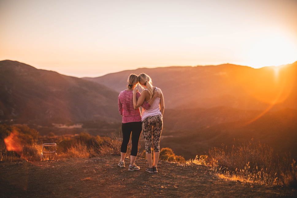A sweet photo of a mom and daughter looking at the sunset.