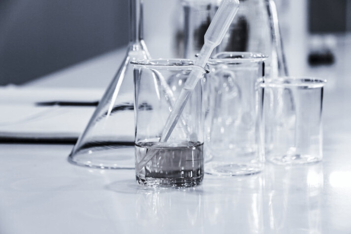 three clear beakers placed on a tabletop in a lab