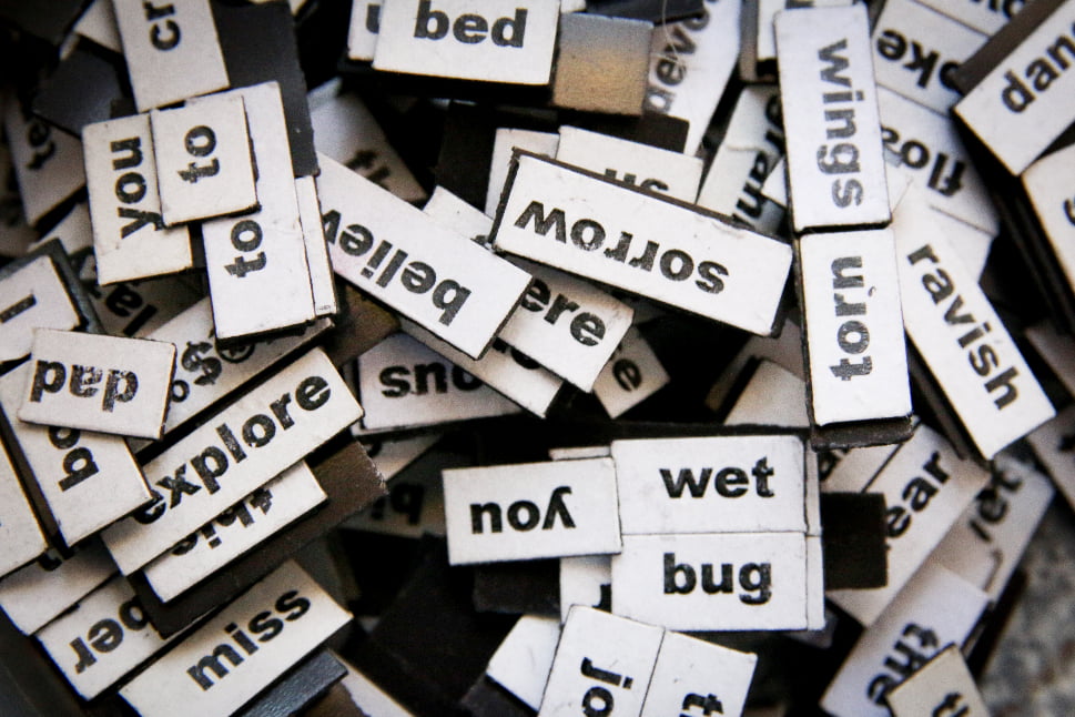 Several word cut-outs that are mixed together on a table.