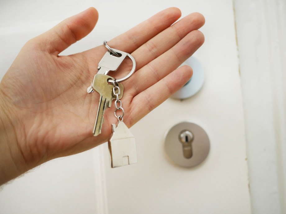 A person holding the keys to their home in the palm of their hand.