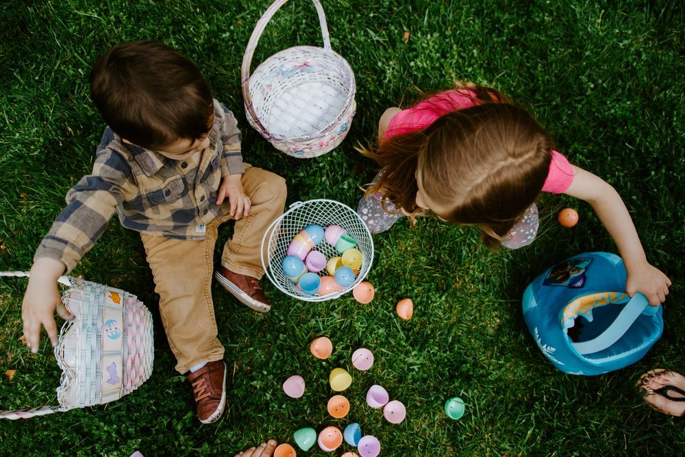 A photo of a boy and girl playing with Easter eggs.