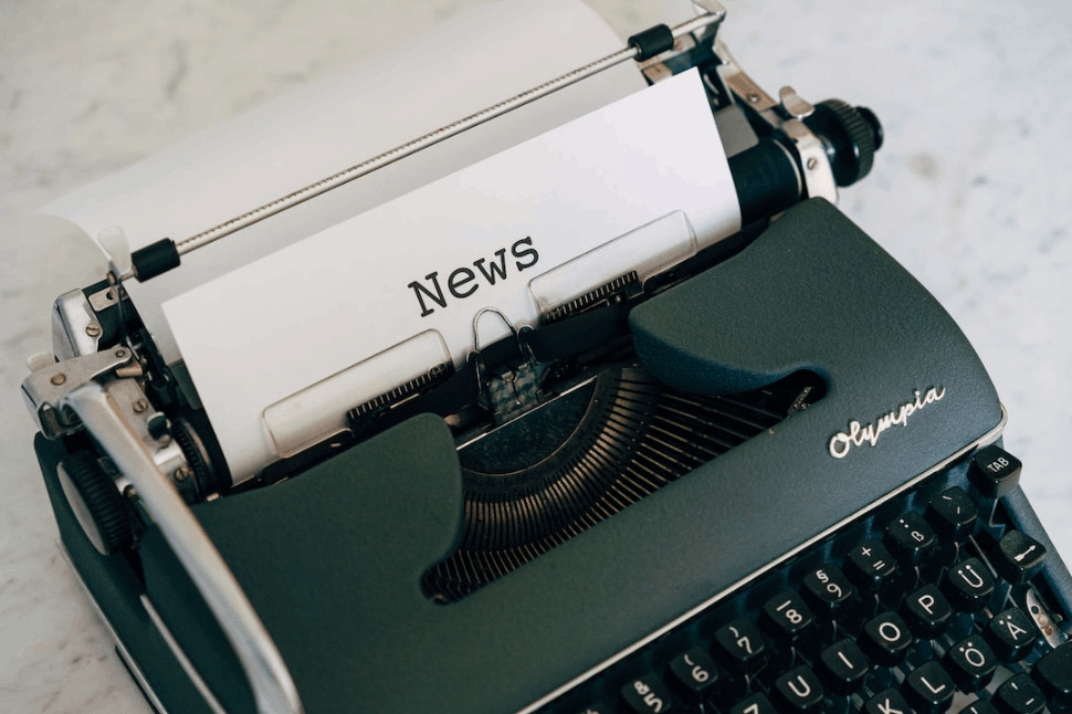An Image of a typewriter with a piece of paper on top that has the word News typewritten on it