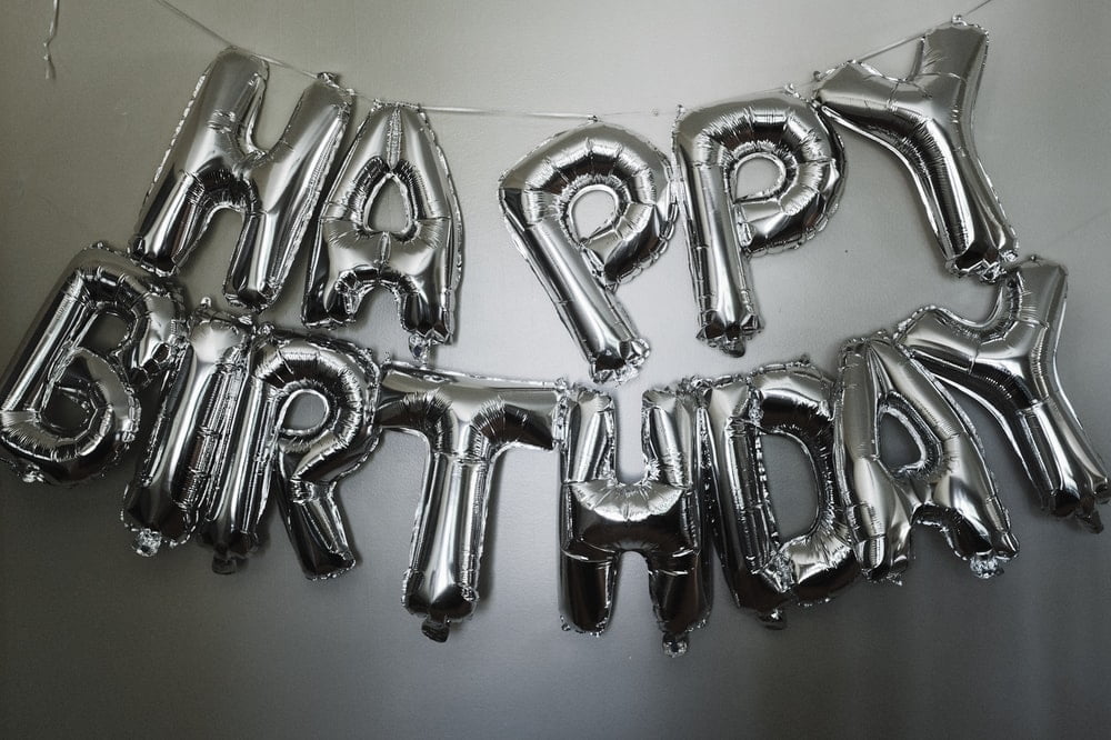 A group of silver letter balloons that spell 
