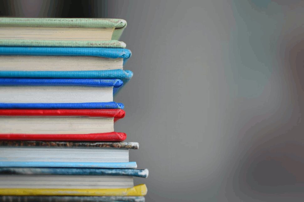 A pile of differently colored books brought into camera focus.