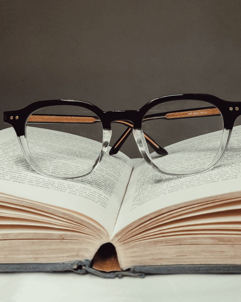 black framed eyeglasses on a book that is half opened.