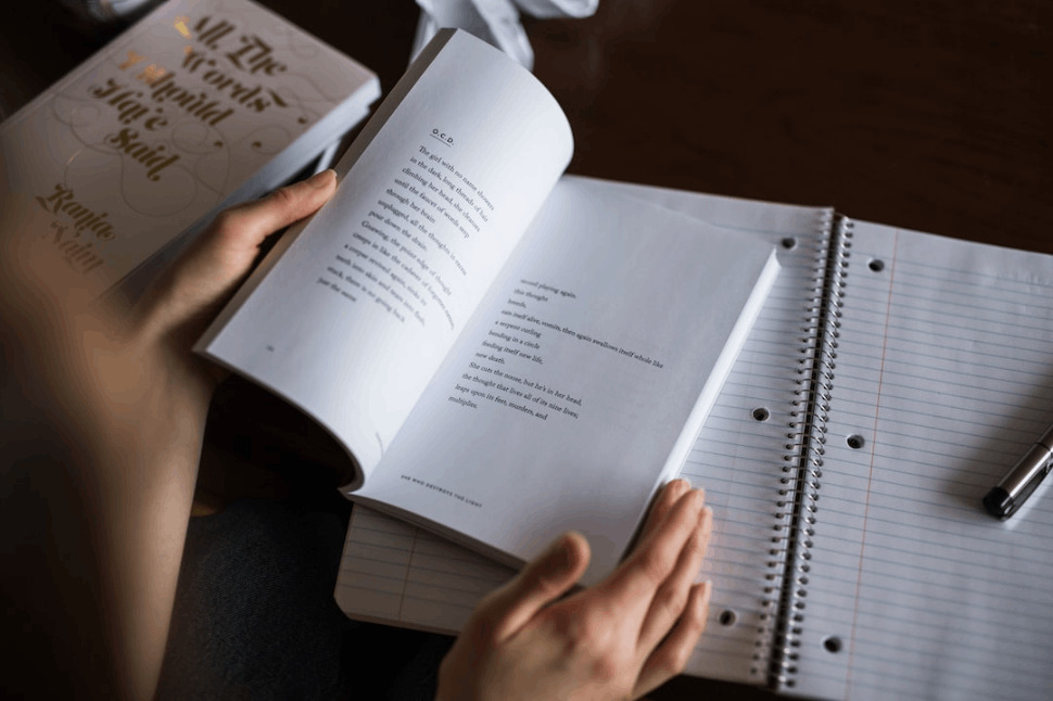 A person flipping a book placed on a black table