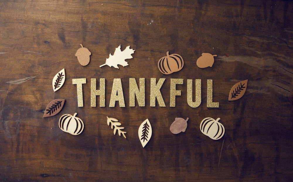 A brown wooden board with the word Thankful