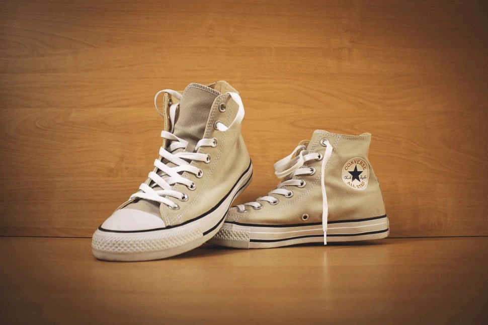 A brown Converse high top shoe on a wooden surface.