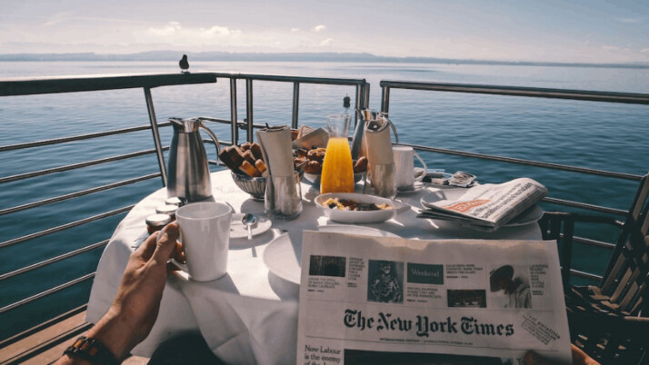 a person holding a white ceramic mug on a cruise