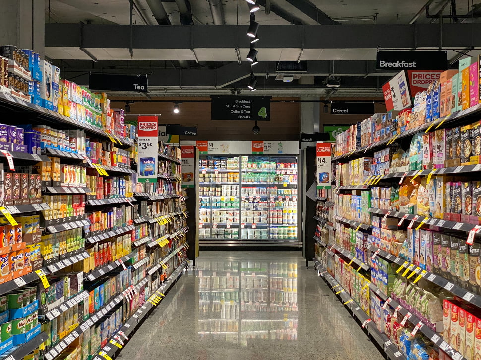 An aisle in a grocery store lined with shelves full of products.