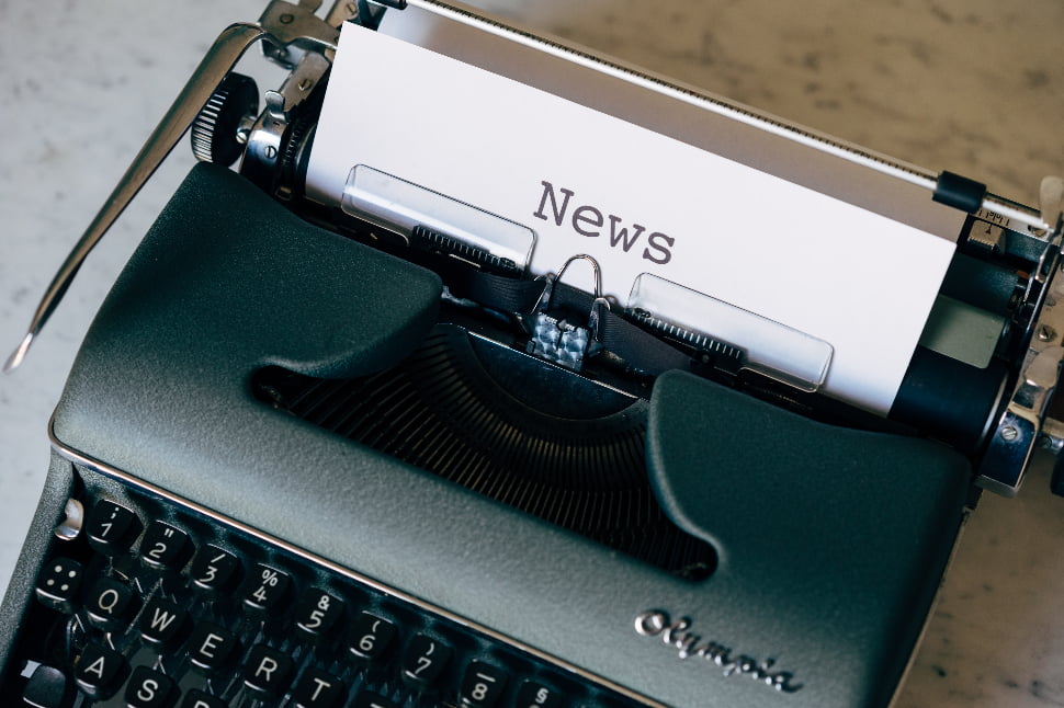A typewriter typing out the word NEWS on a piece of paper.