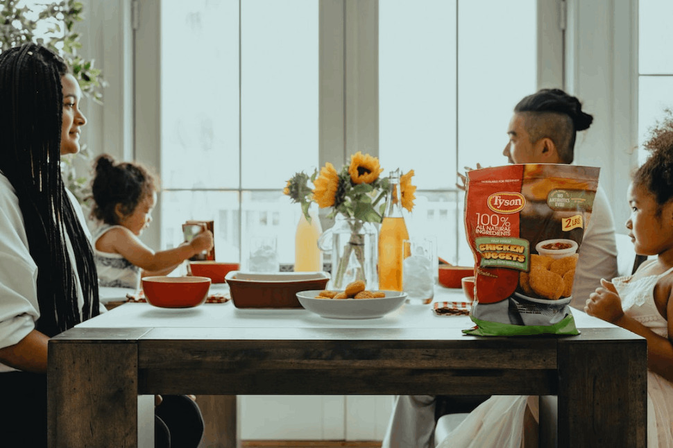 family members sitting on a dining table for breakfast.