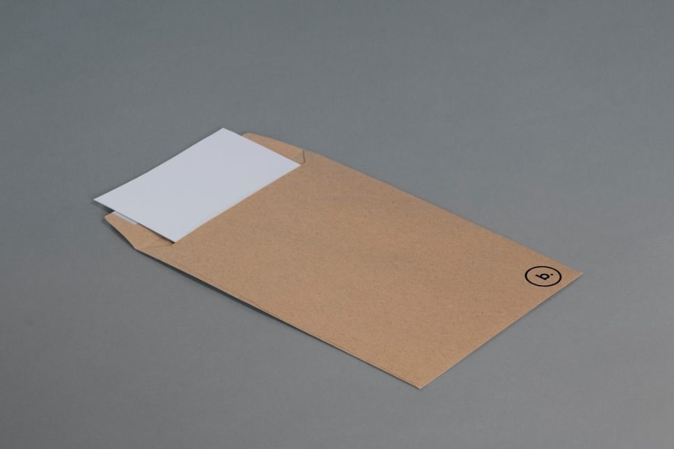 brown envelope on gray surface with white paper slid in it