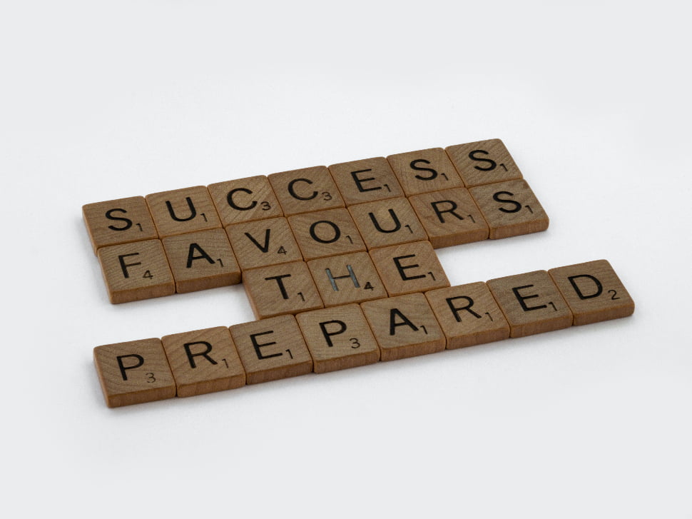 Success Favours the Prepared brown wooden scrabble blocks on a white surface. 
