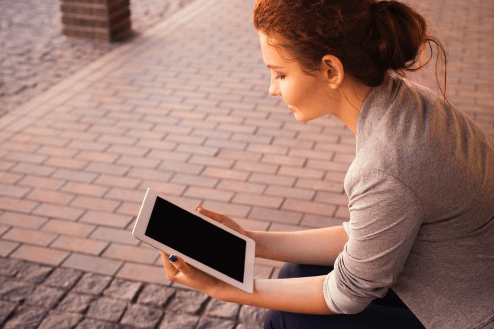 Woman taking advantage of the outdoors while using her tablet