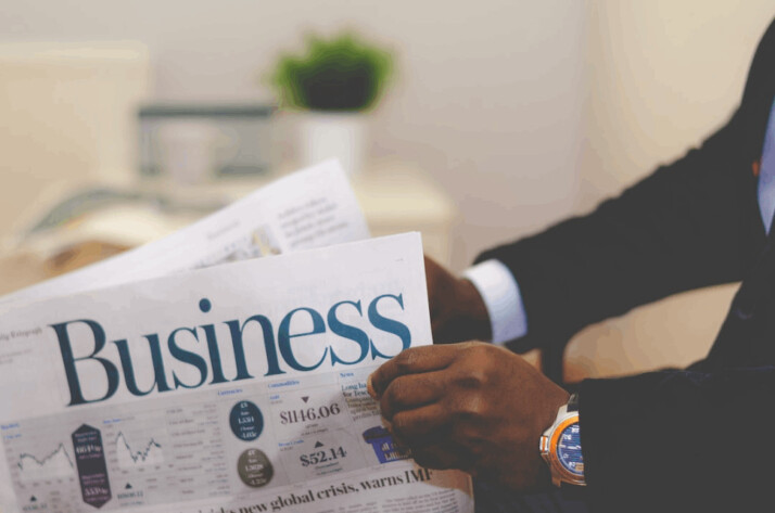 a person wearing a suit reading a business newspaper