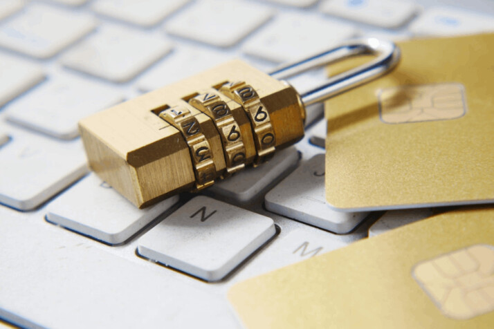 A golden colored lock placed over a white keyboard