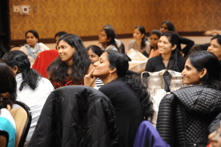 group of women sitting on chair while listening