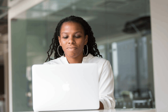 woman wearing white top using MacBook