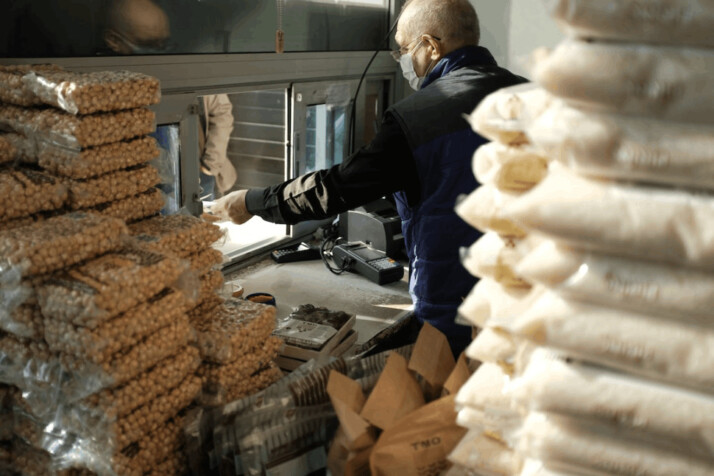 man in black long sleeve shirt holding brown bread