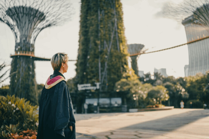 woman in black coat standing on road during daytime