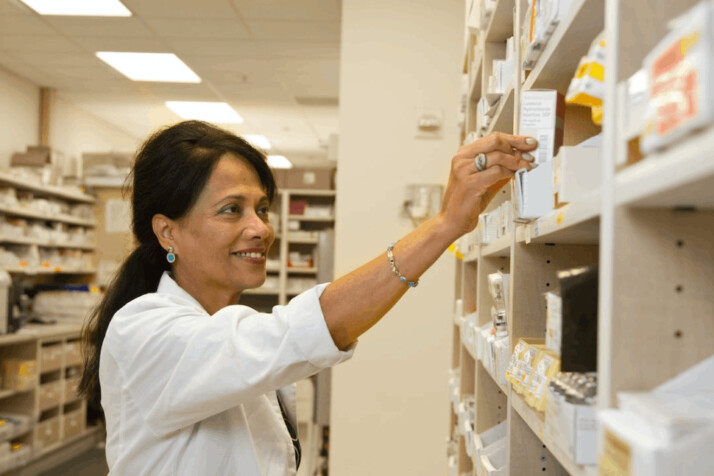 a woman in white dress shirt holding a white medicine box