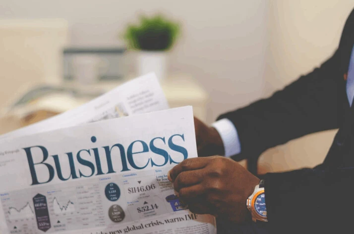 a person wearing a suit reading a business newspaper