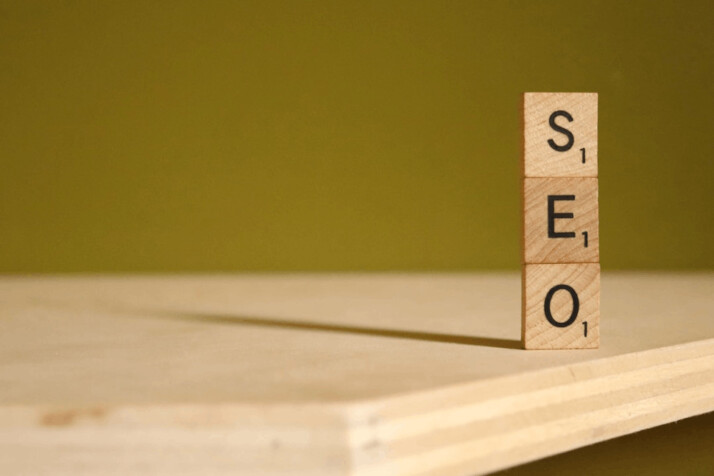 SEO text on brown wooden scrabble block placed over a table