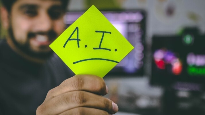 a person holding a lemon-colored card with A.I text written on it