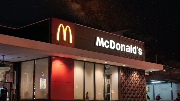 A view of the storefront of a McDonald's during night time.