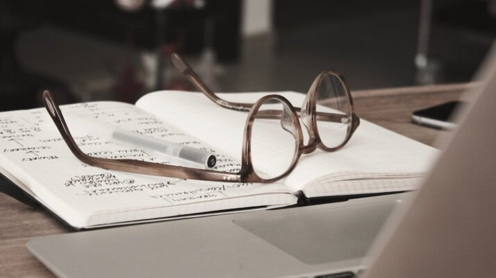 Eyeglasses with gray frames on the top of notebook