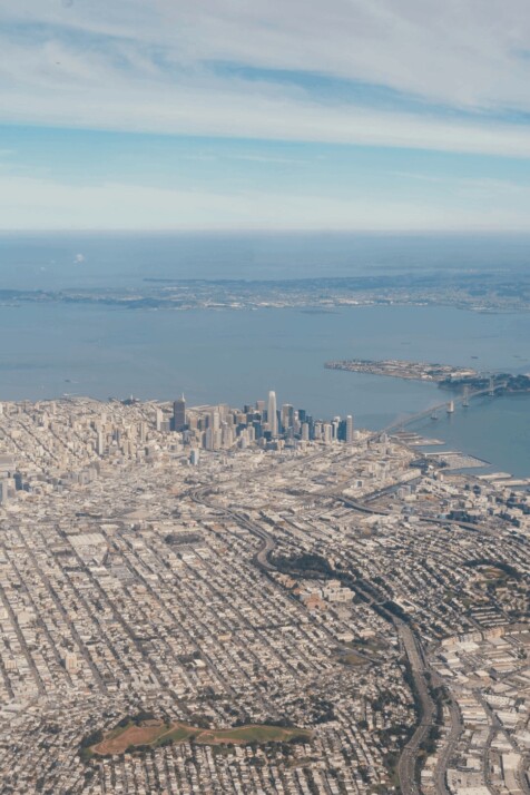 Aerial view of city buildings near body of water during daytime