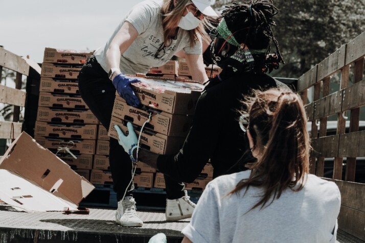 Volunteers helping each other carry boxes during a donation drive.