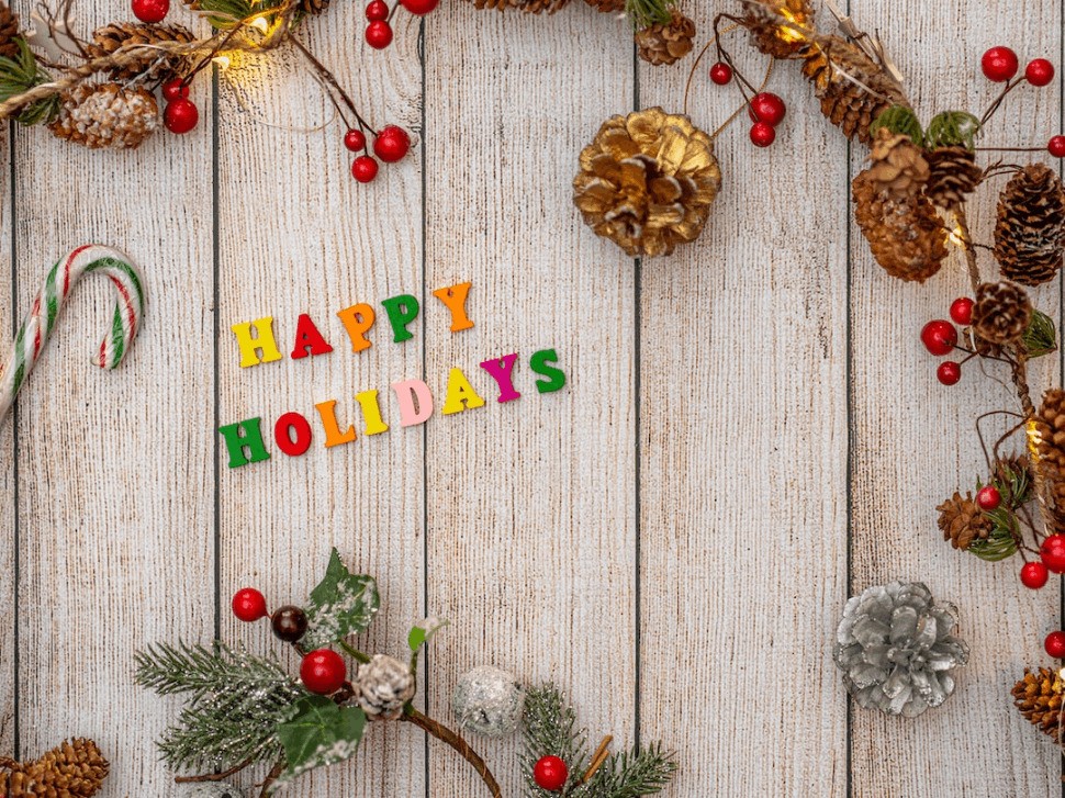 Holiday cheer expressed with 'Happy Holidays' on wooden backdrop.